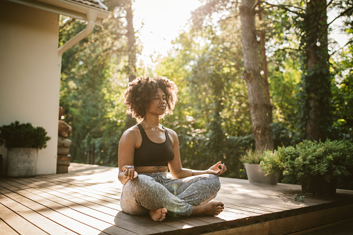woman meditating on a patio outdoors