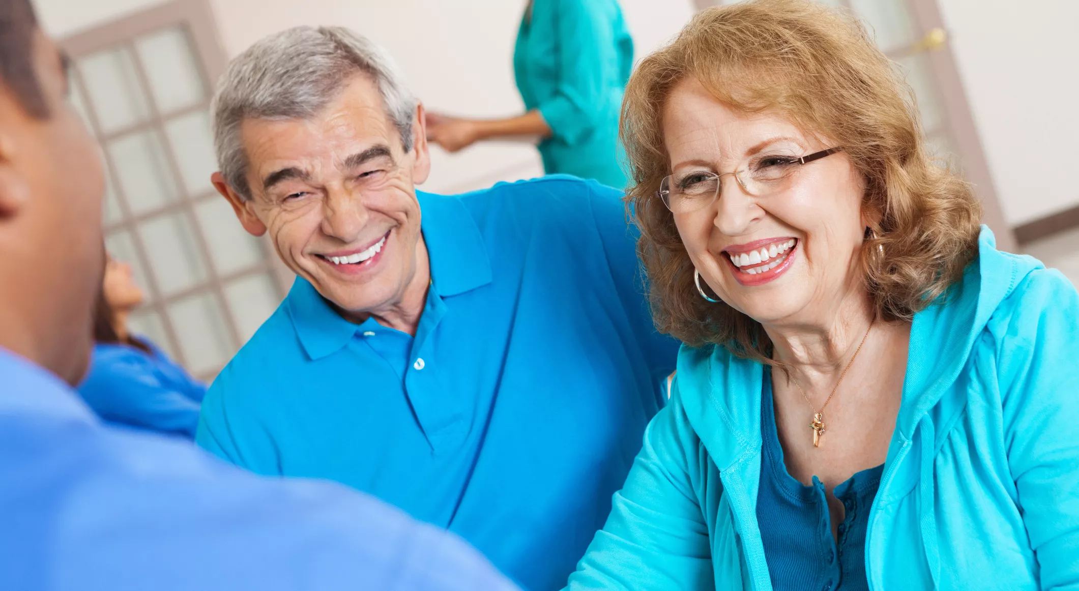 happy senior couple in blue talk with speech therapist