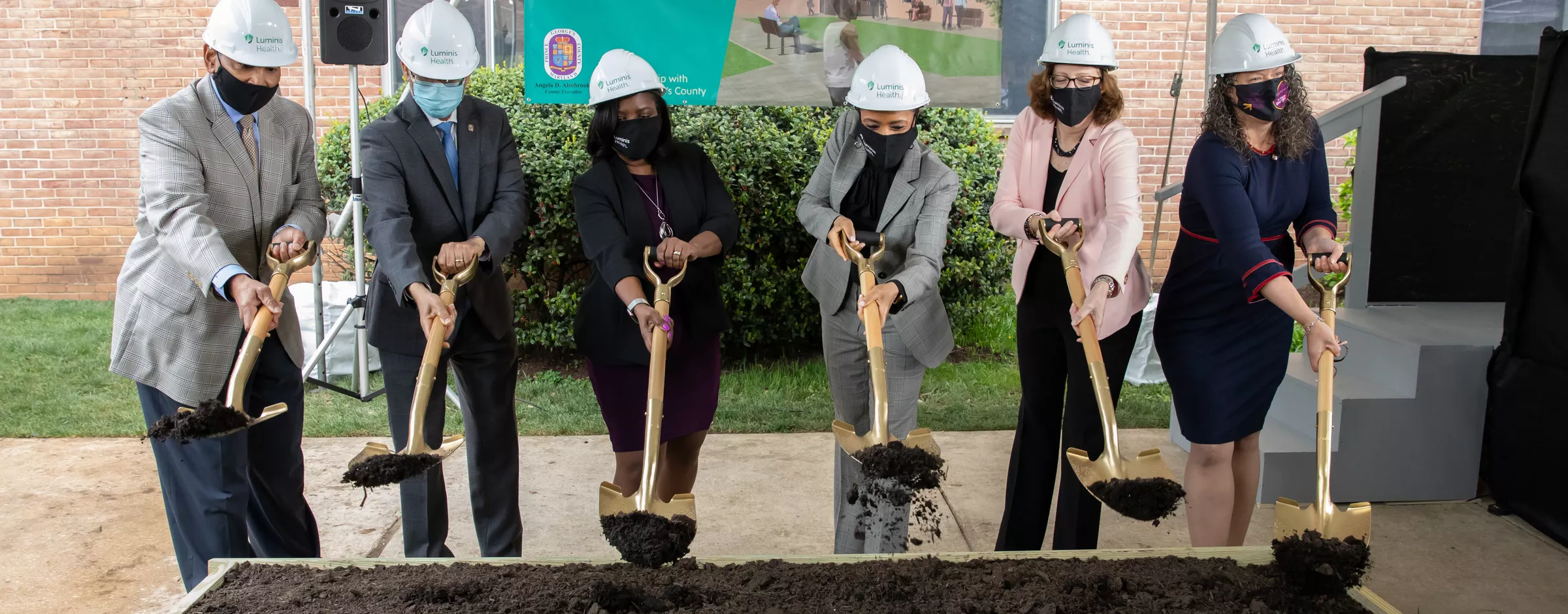 Executives moving dirt at groundbreaking