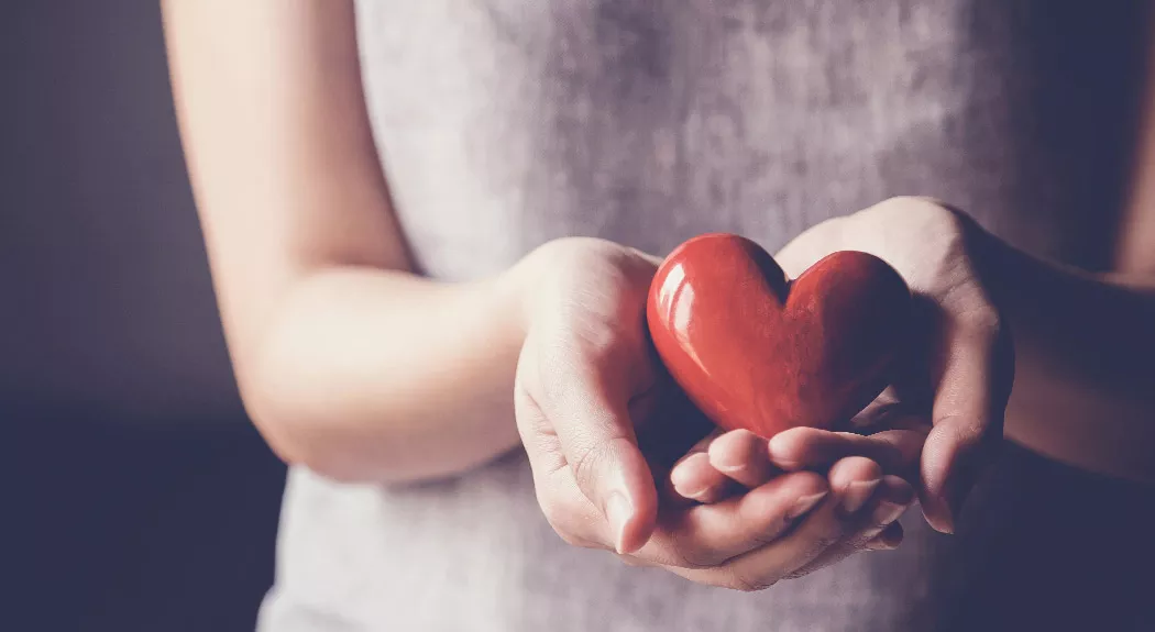 Woman holding heart-shaped object