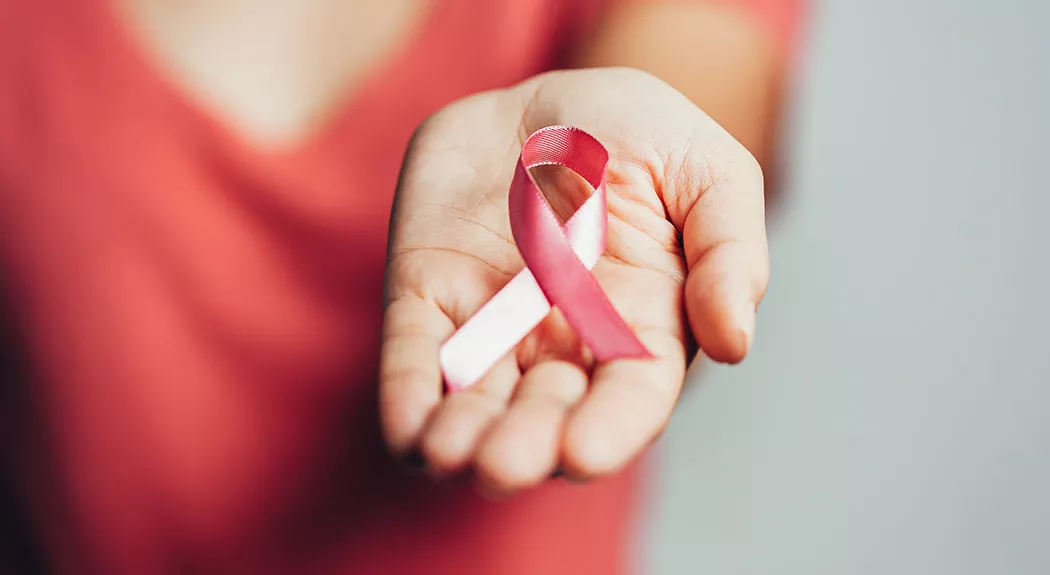 hand holding breast cancer ribbon