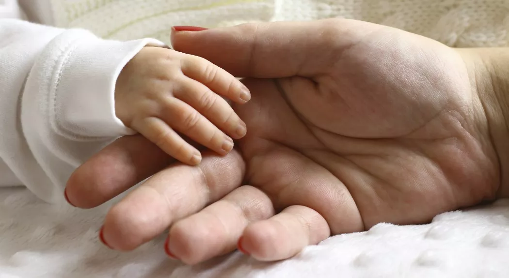 mother holding baby's hand