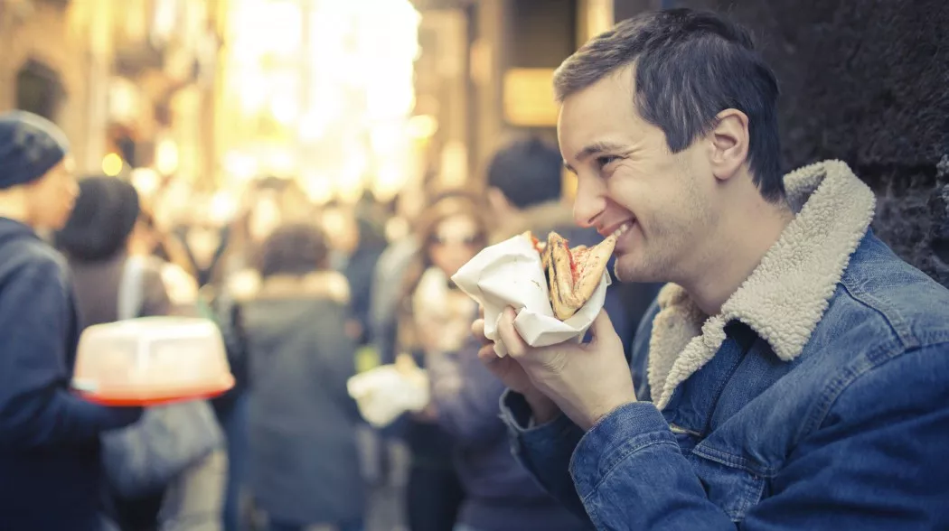 Man eating pizza snack outdoors