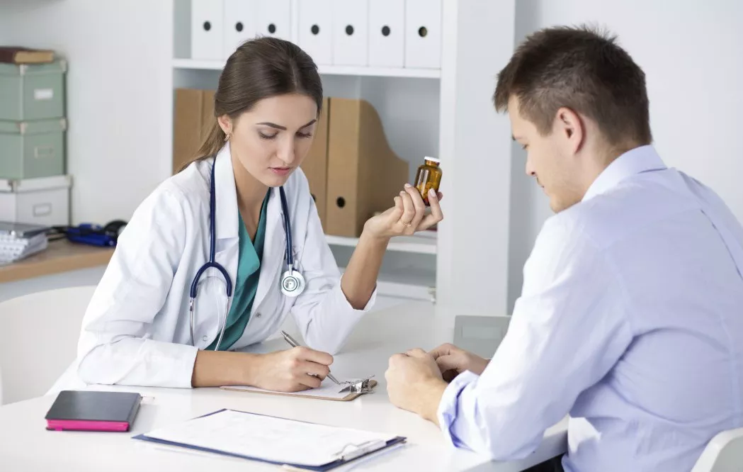 Female medicine doctor prescribing pills to her male patient