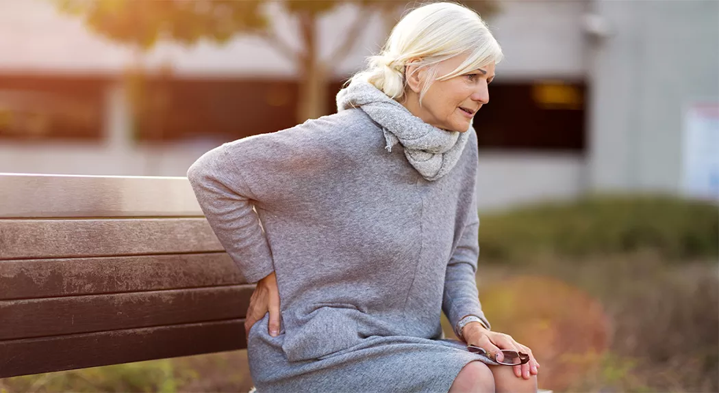 lady-on-bench-with-backpain-1080×575