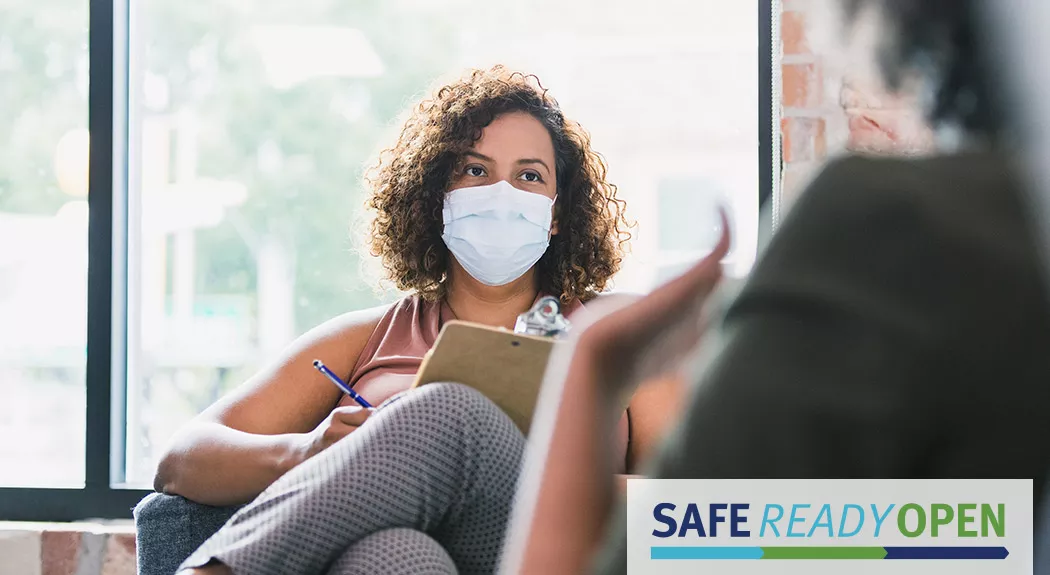 therapist wearing mask talking to patient